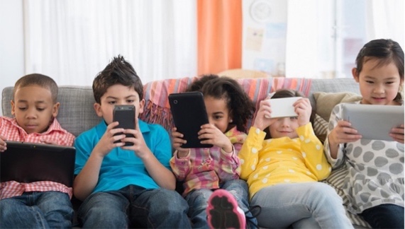 A group of kids sitting on a couch and using their phones

Description automatically generated with low confidence