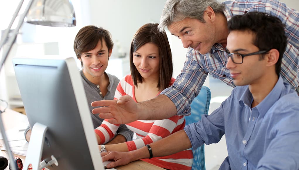 A group of people looking at a computer

Description automatically generated