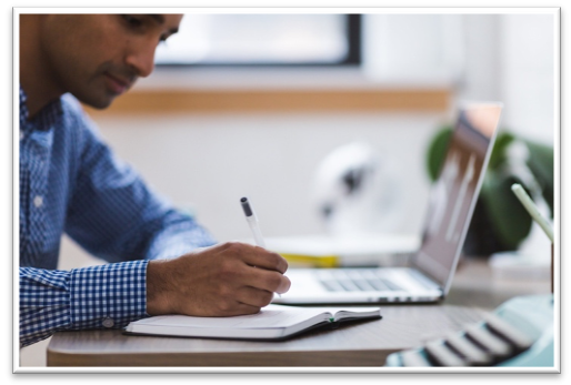 A person sitting at a table using a computer

Description automatically generated