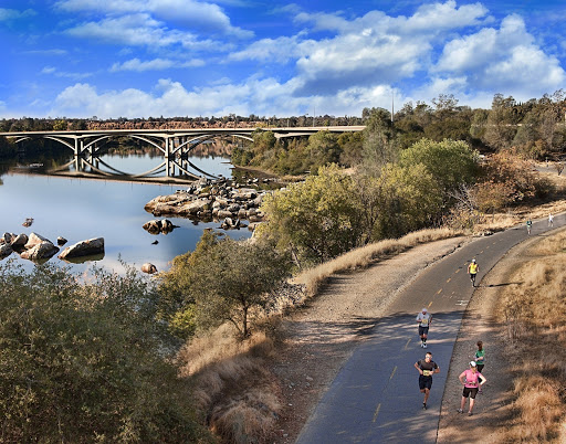 A group of people walking on a path near a bridge

Description automatically generated with low confidence