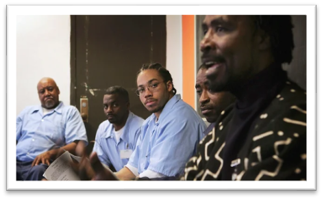 A group of men sitting and looking at the camera

Description automatically generated with low confidence