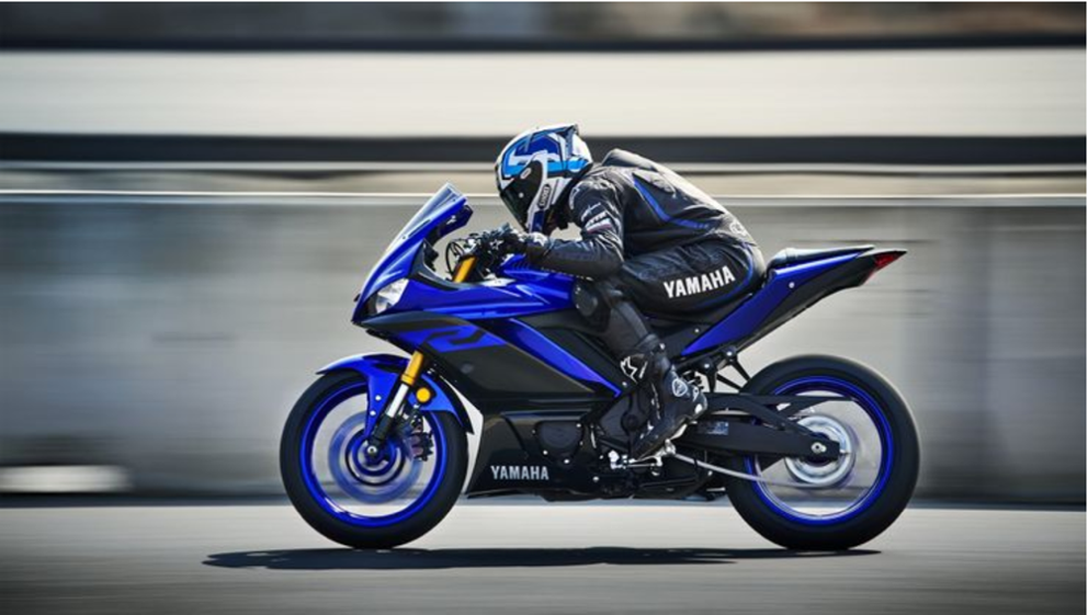 A person riding a motorcycle down a street

Description automatically generated