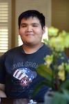 front picture of Zhijun wearing blue navy shirt some plants on the background